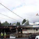 Kirkland firefighters and Puget Sound Energy staff examine the aftermath of a four-hour fire that destroyed the Rose Hill Village. Kailan Manandic/staff photo