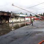 Kirkland firefighters water down hot spots after extinguishing the Rose Hill Village fire on Sept. 12. Kailan Manandic/staff photo