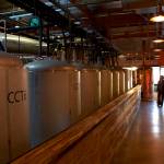 Chainline patrons walk down a line of tanks and brewing equipment before they enter the tap room at the back of the space. Kailan Manandic/staff photo