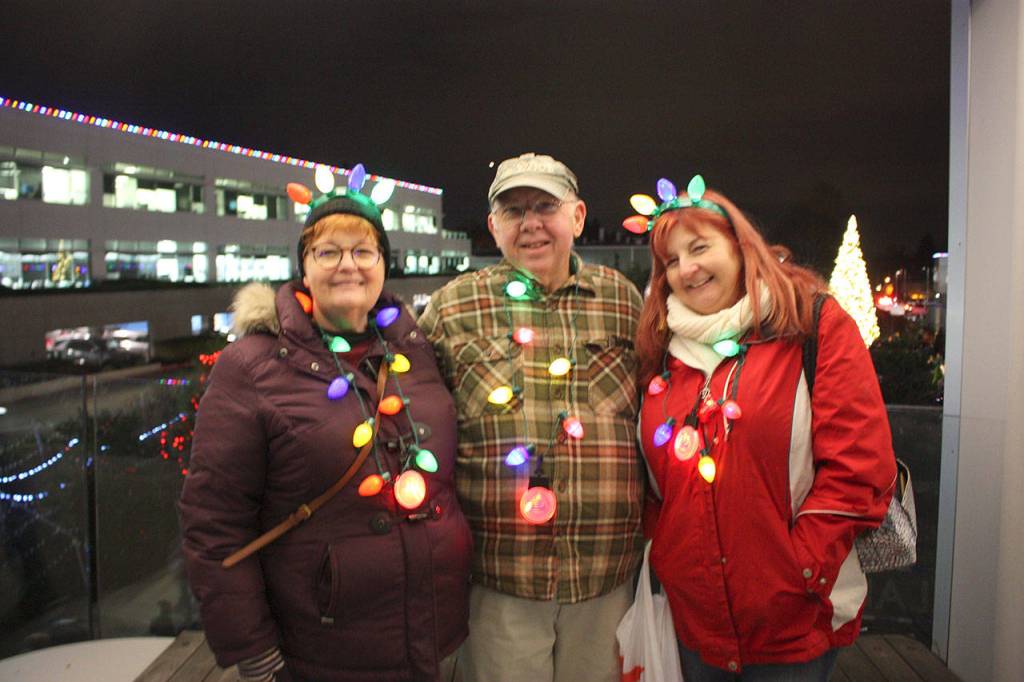 L-R: Melisa Lepinski, Russ Coed, and Kathy Scott watch the musical holiday lights show from the skybridge. Stephanie Quiroz/staff photo.