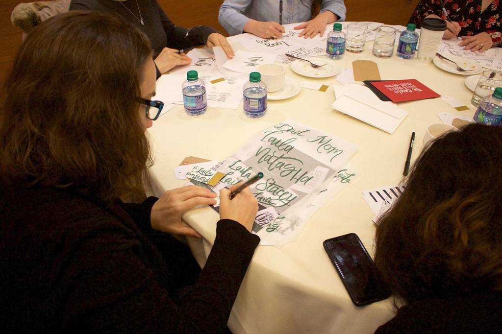 Attendees learn how to elevate seasonal gift wrapping with hand-lettered holiday cards. Stephanie Quiroz/staff photo
