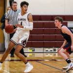 Mercer Island Islanders junior Adam Parker, left, looks for a teammate to pass to against the Juanita Rebels. Parker finished with a team-high 20 points against the Juanita Rebels on Dec. 11. The Islanders defeated the Rebels 56-49. Photo courtesy of Rick Edelman/Rick Edelman Photography