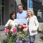 From left: Flower Pot program chair Anne Hess, KDA executive director Michael Friedline, and Flower Pot program chair Kathy Feek pose near flower pots in downtown Kirkland with a sample of the new plaques. Stephanie Quiroz/staff photo.