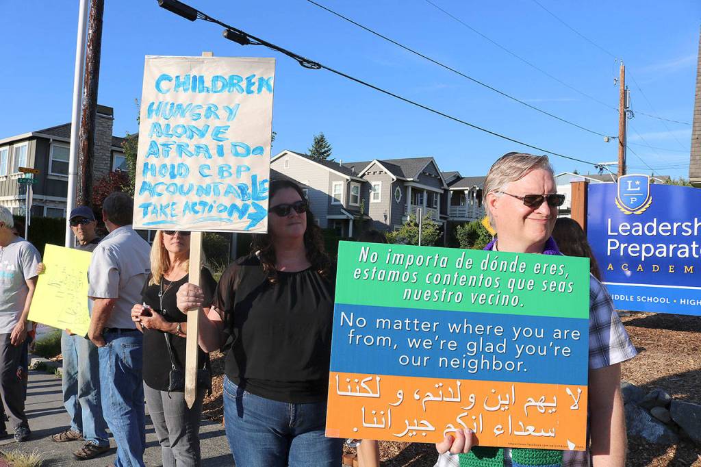 Protestors hold signs that read, Children Hungry Alone Afraid. Hold CBP Accountable. Take Action, and No matter where you are from, were glad youre our neighbor on July 12. Stephanie Quiroz/staff photo