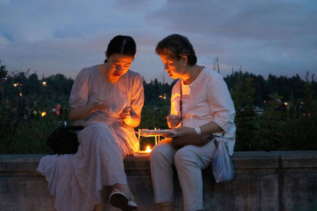 Festival attendees build a lantern at Juanita Beach Park on Aug. 10. Stephanie Quiroz/staff photo