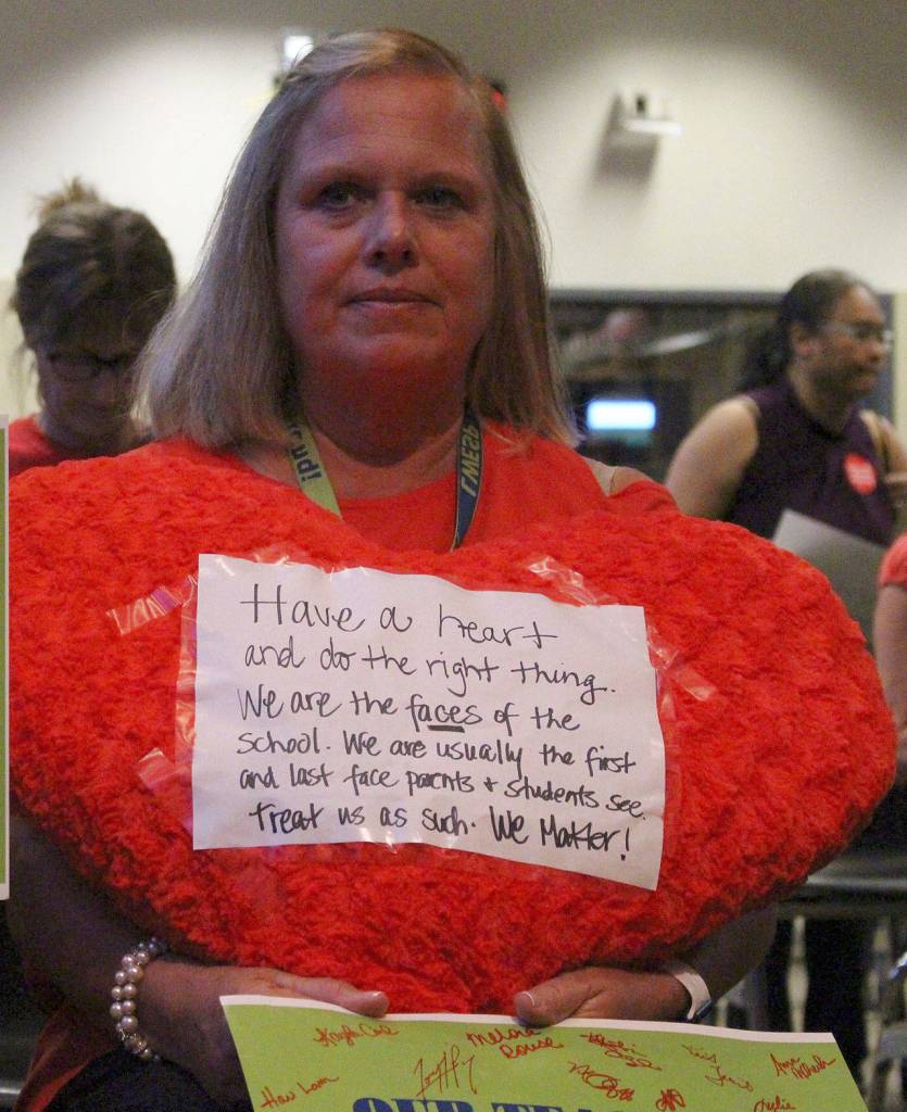 Peg Jatekar, a healthroom secretary at Laura Ingalls Wilder Elementary School, held a plush heart with a handwritten note attached at the school board meeting. The note read Have a heart and do the right thing…We are the faces of the school. We are usually the first and last face parents and students see. Treat us as such. We matter! Madison Miller/staff photo