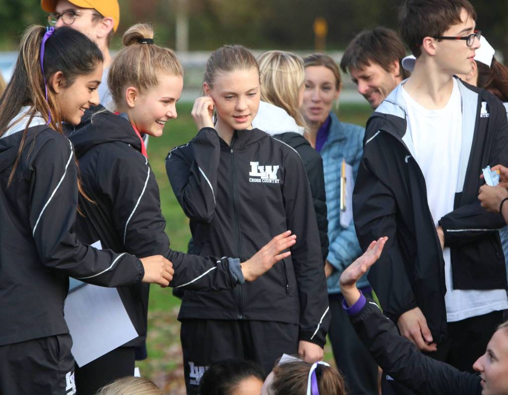 Kang Belle Brandenfels, second from left, high fives a teammate after the KingCo awards ceremony. Andy Nystrom/ staff photo