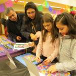 From left, Luis Nunez, Catalina Nunez, Angie Nunez and Leslie Gonzalez pick out items at the Dia De Los Muertos celebration in downtown Issaquah. The items are for a miniature altar they will create as a family. Samantha Pak/staff photo