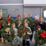 Volunteers from ParentMap join the women of the Terese Smith Howard heritage circle to help tie bows to the wreaths and prepare them for selling. Photo courtesy of Maureen Taasin