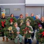 Volunteers from ParentMap join the women of the Terese Smith Howard heritage circle to help tie bows to the wreaths and prepare them for selling. Photo courtesy of Maureen Taasin