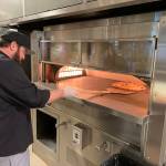 Dustin Nick, executive chef at DigiPen Institute of Technology, prepares a pizza for delivery for its new DragonDrop service. Photo courtesy of DigiPen Institute of Technology