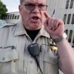 A sheriffs court marshal confronts someone recording the doughnut incident. (Screen grab from video courtesy of Bennett Haselton)