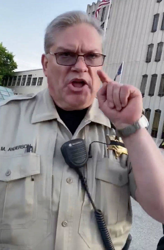 A sheriffs court marshal confronts someone recording the doughnut incident. (Screen grab from video courtesy of Bennett Haselton)