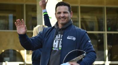 Seahawks head coach Mike Macdonald waves and holds the Lombardi Trophy during the parade. Photos by Ben Ray / Sound Publishing