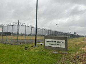A sign and fence at the Green Hill School for juvenile offenders, in Chehalis, Washington. (Photo by Jake Goldstein-Street/Washington State Standard)